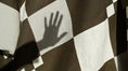 Load image into Gallery viewer, Checkered fabric with a hand casting a shadow on it
